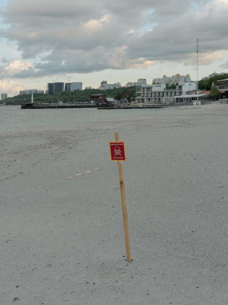 A famous beach resort in Ukraine. A sign warning the existence of landmines is in the sand