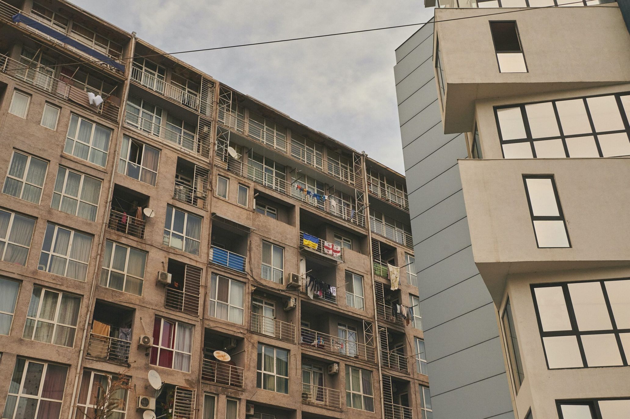 A new building stands right next to a Soviet-era housing complex (left). One of the most common sights in Tbilisi.