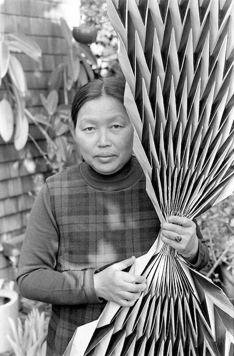 Laurence Cuneo, Ruth Asawa holding a paperfold, c. 1970s. Gelatin silver print, 9 13/16 × 7 5/16 in. (24.9 × 18.6 cm). Courtesy of the Department of Special Collections, Stanford University Libraries. Photograph © Laurence Cuneo. Artwork © 2023 Ruth Asawa Lanier, Inc. / Artist Rights Society (ARS), New York. Courtesy David Zwirner
